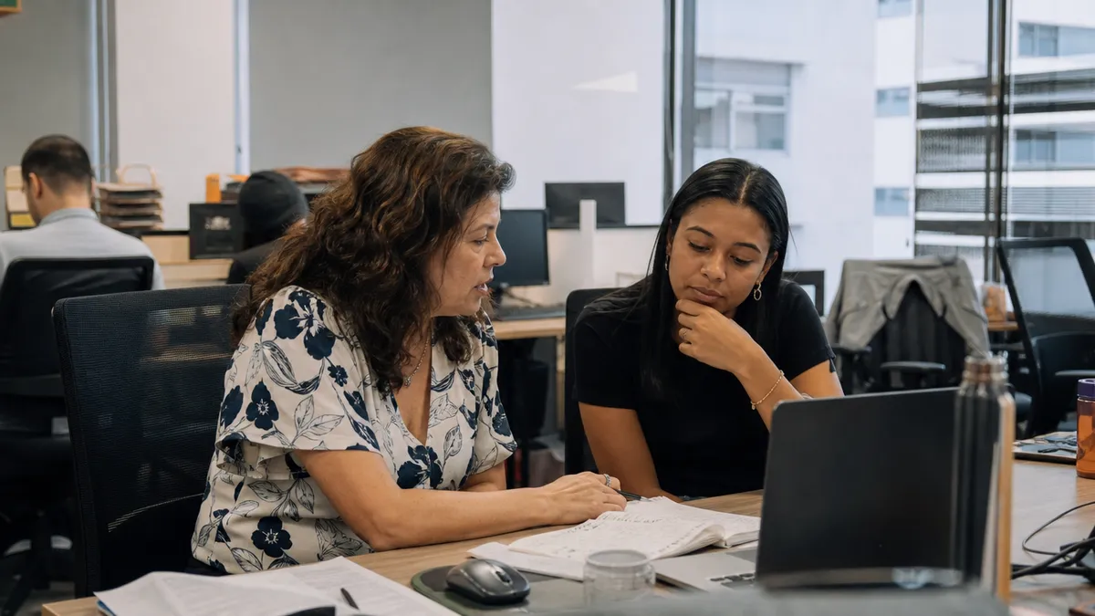 Duas gerações em ambiente de trabalho cotidiano / conversa de equipe.